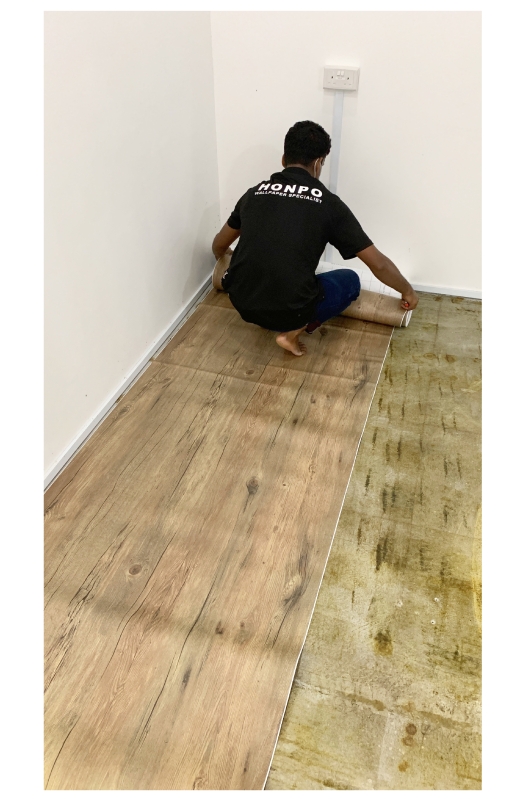 honpo professional installer working on flooring in a room